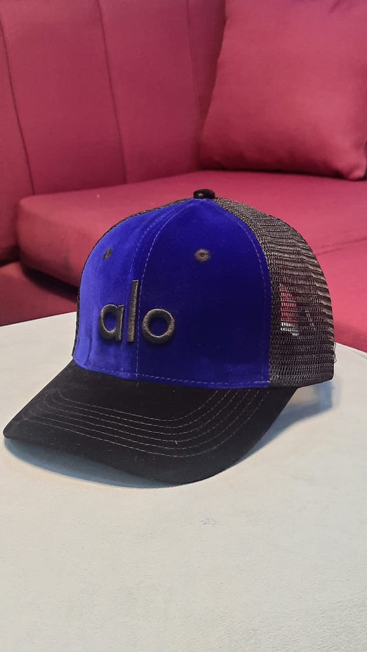 Alo Velvet Trucker Hat in a blue/black colorway.